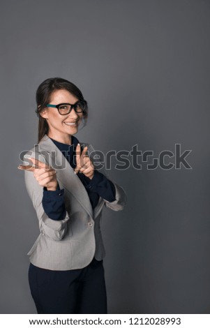 funny  business woman  is standing on a gray background. with glasses .business concept