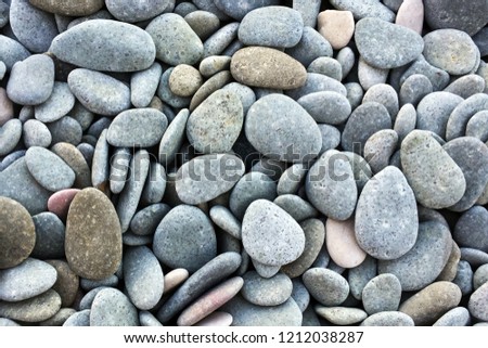 Naturally polished Colorful and round stones texture on the ground. 
