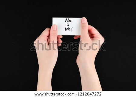No is no text on a card in woman hand  on a black background.