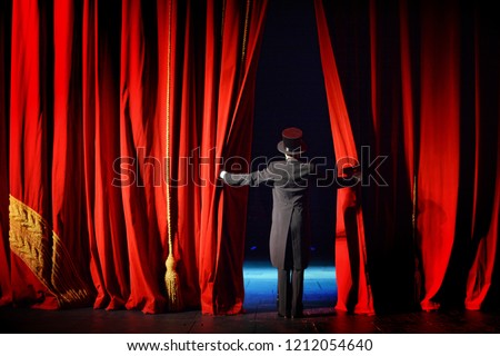 The actor in a tuxedo theatre closes the curtain Royalty-Free Stock Photo #1212054640
