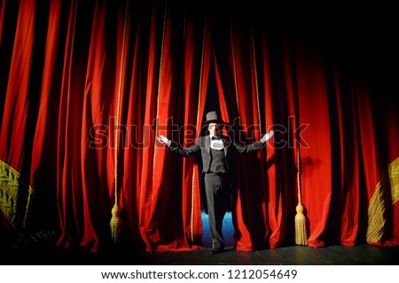 The actor in a tuxedo theatre closes the curtain Royalty-Free Stock Photo #1212054649