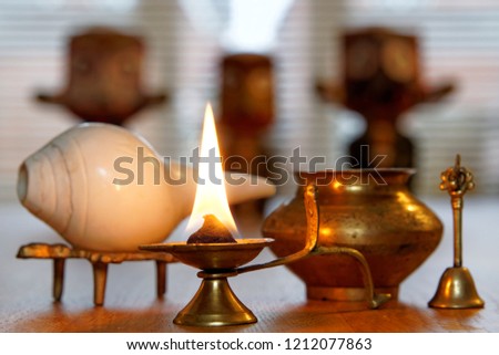 Burning ghee candle with Puja set for religious offerings in Hindu tradition