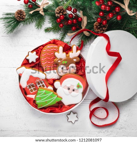Christmas gingerbread cookies of different shapes in a festive box on a white wooden background close-up. Christmas. New year concept. View from above. Flat layout. Square frame