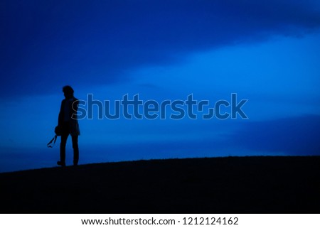 Men silhouette standing on a hill