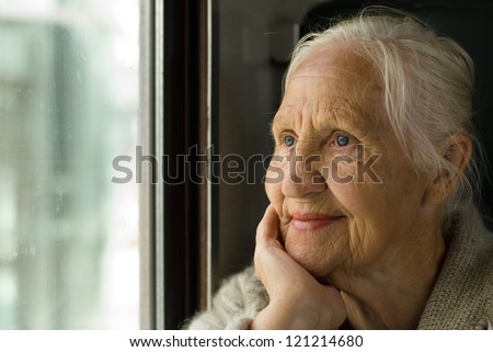 Lovely grandmother looking in a window, in a train Royalty-Free Stock Photo #121214680