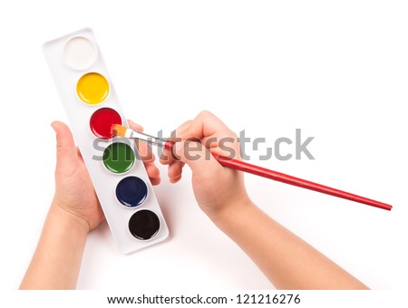 child's hand paints with watercolors and brush