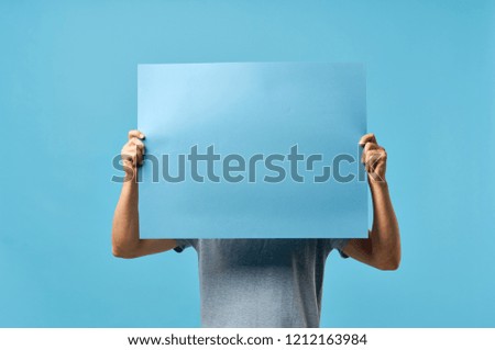 man covers his face with blue mockup poster                        