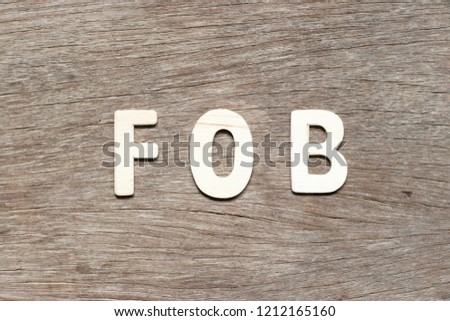 Alphabet letter in word FOB (abbreviation of free on board) on wood background