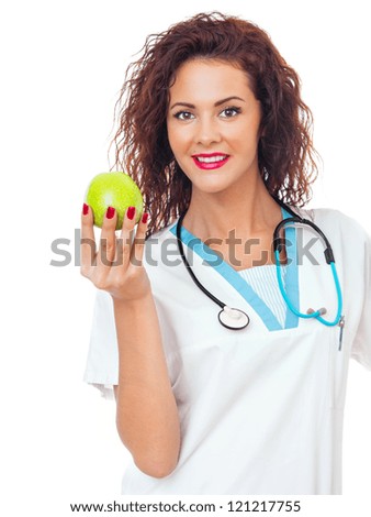 Happy young woman doctor with stethoscope and green apple. Isolated on white