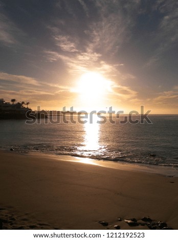 Beautiful nature background of sunset over beach in Playa Blanca, Lanzarote, Canarian Islands. Sunlight and Atlantic ocean. Vacations, tourism and nature concept.