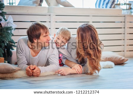 Beautiful family in pajamas lying on the floor / copy space