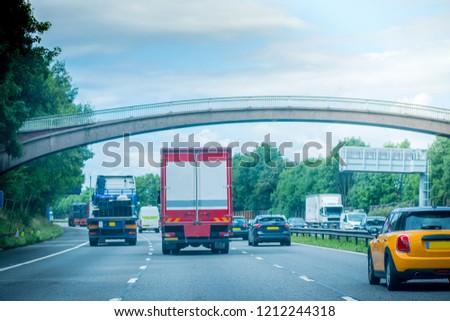 Closeup of busy Highway transportation  motorway full of cars in the evening with dark cloudy blue sky, going under bridge