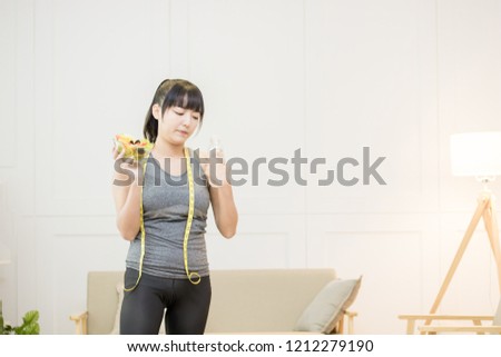 Portrait of a fit healthy asian woman holding a fresh salad and 