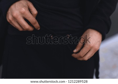 Man tying the lace on sports trousers. Man wearing black sport suit. Clothing details. 