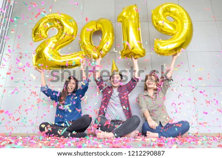 Three friends Enjoying Party  together hold numbers indicating the arrival of a new  year 2019, celebration of happy new year Party 