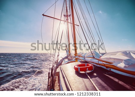 Sailing against the sun, travel and adventure concept, color toned picture.