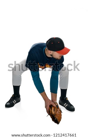 Portrait of a pitcher in action, isolated on white. Young man bent over, dressed in a uniform and wearing a leather glove.