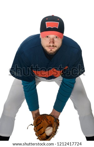 Pitcher caught a ball. Portrait of a young man bent over and dressed as a baseball player, isolated on white.