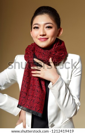 Asian girl wearing a crimson scarf in yellow background