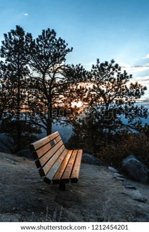 Reflection of sunset on a park bench in the mountains