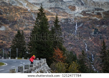 Photographer taking pictures of autumn landscape in Switzerland