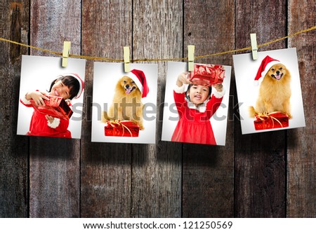 Photos of little girl and dog wearing Santa Claus hat  hanging in the old room.
