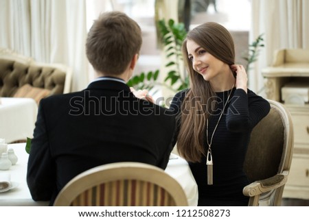 Seducing beautiful woman looking at her lover. Having romantic talk. Valentine's Day