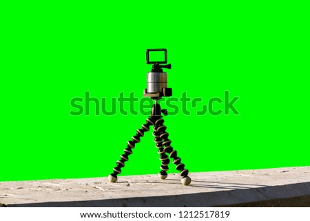 view of the action camera mounted on a tripod isolated on a green background