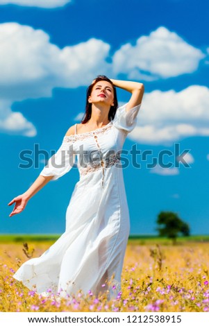 photo of the beautiful young woman standing on the field