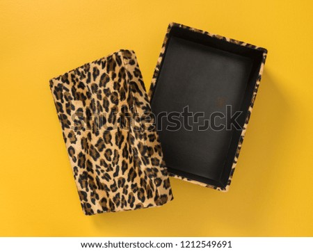 Storage box with classic leopard print, on bright yellow background.