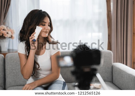 attractive smart woman in casual doing video blogging about beauty product at home