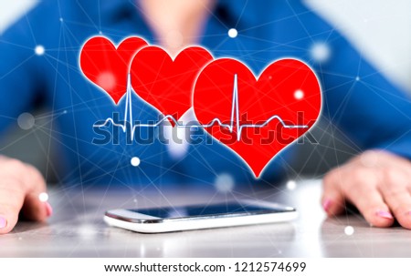 Smartphone with a heart beats graph concept between hands of a woman in background