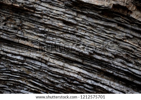 Grey sandstone wall of a rock in a cave during a cloudy day.