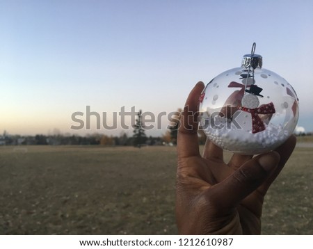 An African American woman holding a Christmas ornament 