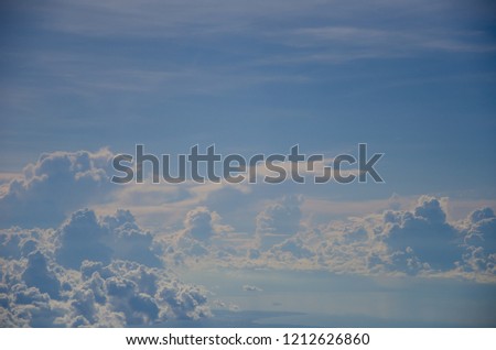 Blue sky background with white  fluffy clouds texture and lighting  in good weather on summer.Take a photo from airplane.
