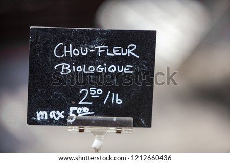 Chalk sign selling organic cauliflower in a french canadian farmer's market under the name chou-fleur biologique - Closeup picture on the sign mounted on a clip, with blurry background