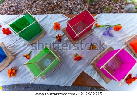 Various colors of silk lantern boats mounted on cedar wood and displayed on white fabric - 1/2 - Wide angle picture taken from above