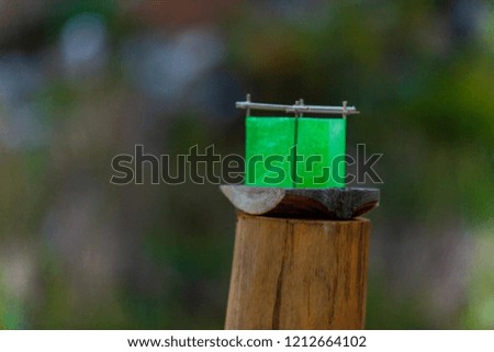 Green silk lantern boat on a wooden pole - Closeup picture taken outside with a blurry background