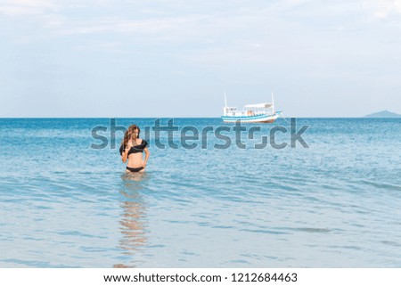 beautiful girl standing waist-high in the sea
