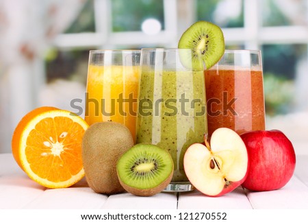 fresh fruit juices on wooden table, on window background Royalty-Free Stock Photo #121270552
