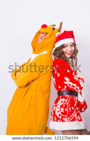 People, family and christmas concept - lovely couple in christmas costumes near christmas tree on white background.