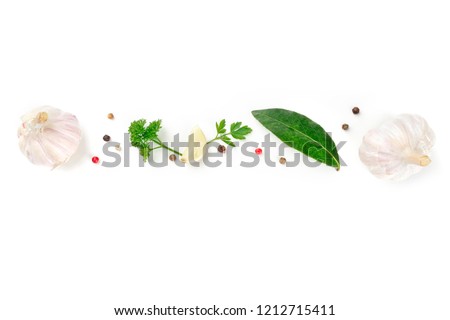An overhead photo of a border with garlic, herbs, and peppercorns with copy space. A cooking design with spices and a place for text, shot from the top on a white background