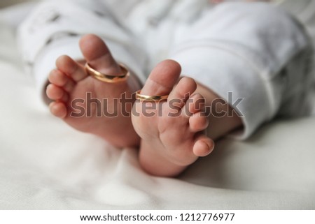 Gold wedding ring on the leg of the baby. Wedding background, wedding card