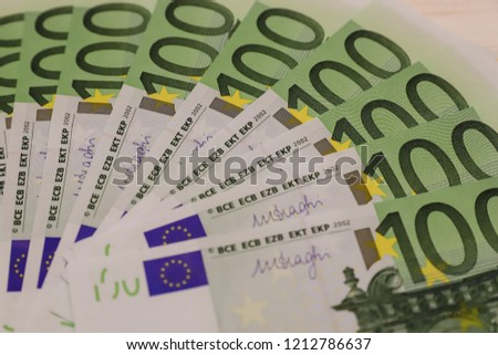 Close up view of group of one hundred euro banknotes on white wooden table. Concept of family budget, earnings, pay day, financial instrument, wealth
