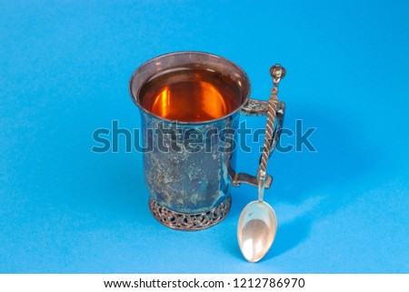 vintage silver cup of tea on a blue background