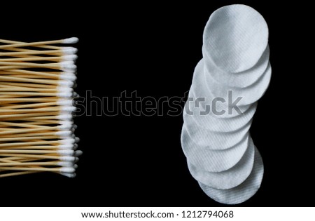 Cotton pads and cotton buds on a black background