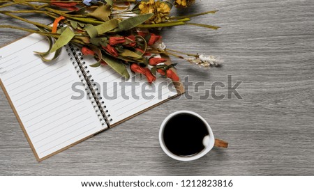 Open notebook with blank pages, coffee and flowers on flat lay top view wood counter top background