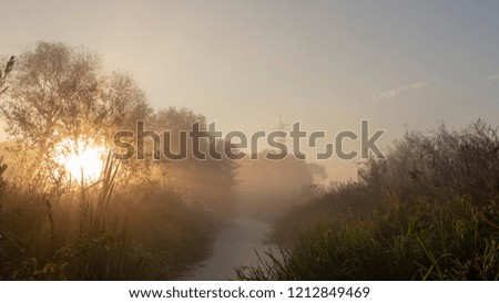 Morning fog on the river. With beautiful rays of the sun against the gray morning sky