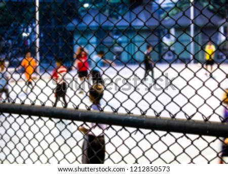 Blurry picture of. Children and teen  play indoor futsal at evening.