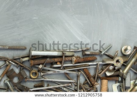 nuts, washers, bolts, screws of various sizes and shapes over the plain background. A set for the mechanic